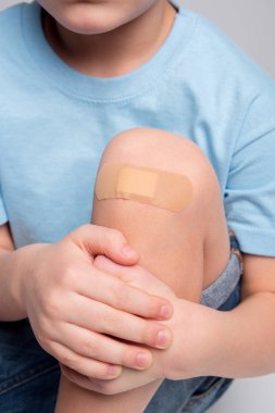 Little boy with patch on knee clipart