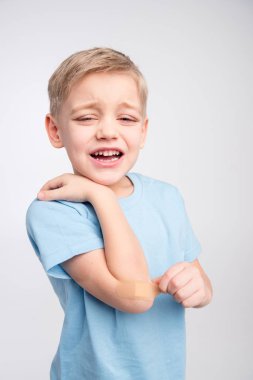 Little boy with patch on elbow clipart