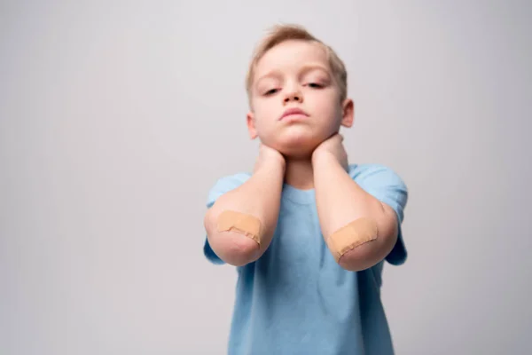 Little boy with patches on elbows — Stock Photo, Image