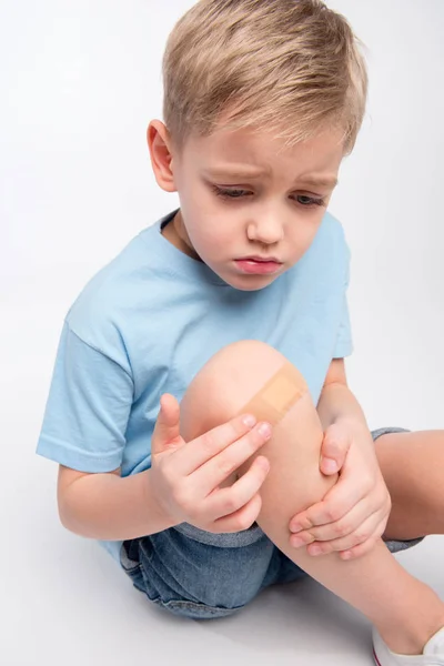 Little boy with patch on knee — Stock Photo, Image