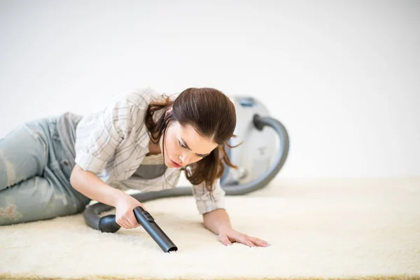 Kvinna vacuuming carpet — Stockfoto