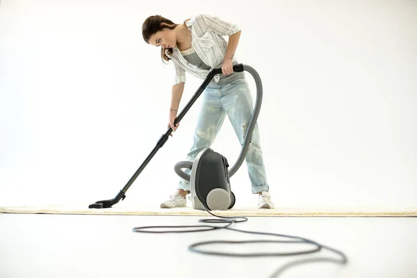 Kvinna vacuuming carpet — Stockfoto