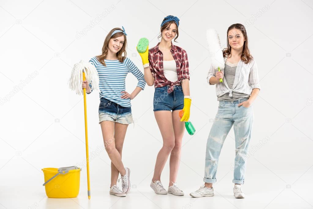 Young women with cleaning supplies