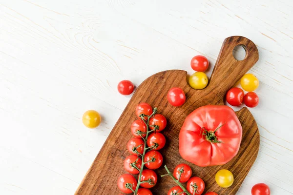 Tomatoes and cutting board — Stock Photo, Image