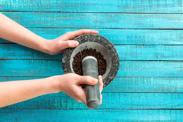 Mortar and pestle in hands — Stock Photo, Image