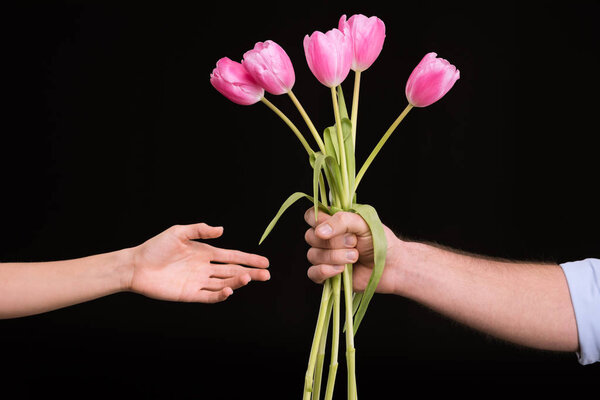 Man presenting tulips to woman