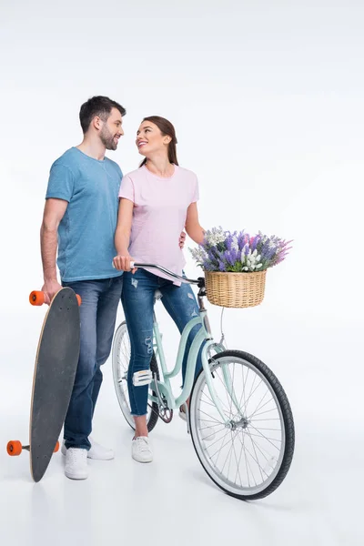 Pareja con monopatín y bicicleta — Foto de Stock