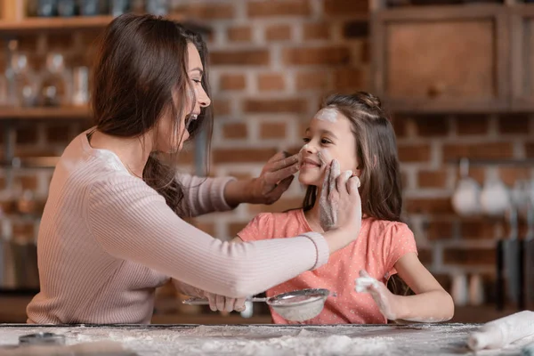 Mor och dotter siktar mjöl — Stockfoto