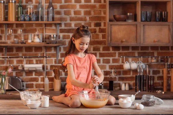 Маленька дівчинка випікає тістечко — стокове фото