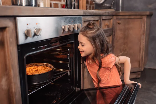 Girl with cake in oven — Stock Photo, Image