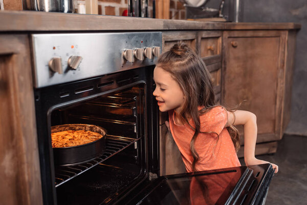 girl with cake in oven