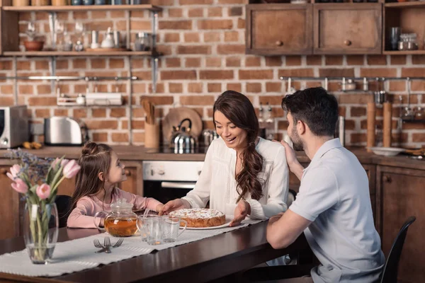 Family with cake in kitchen — Stock Photo, Image