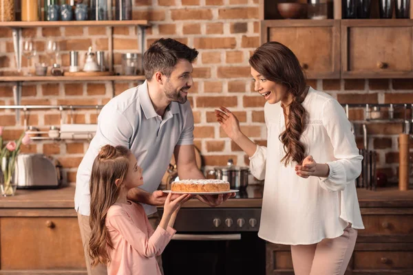 Familia con pastel en la cocina — Foto de Stock