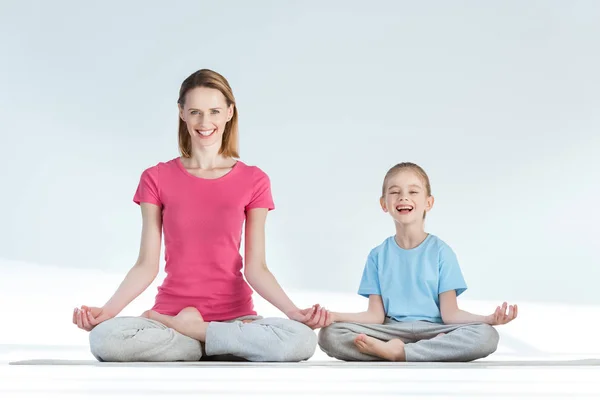 Mother and daughter in lotus position — Stock Photo, Image
