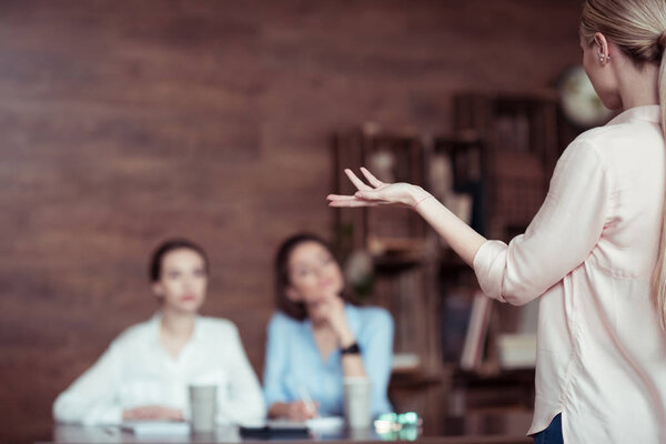 business woman telling something to colleagues
