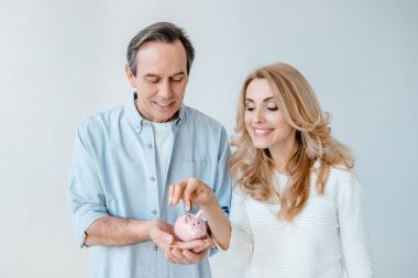 Mature couple with piggy bank  clipart