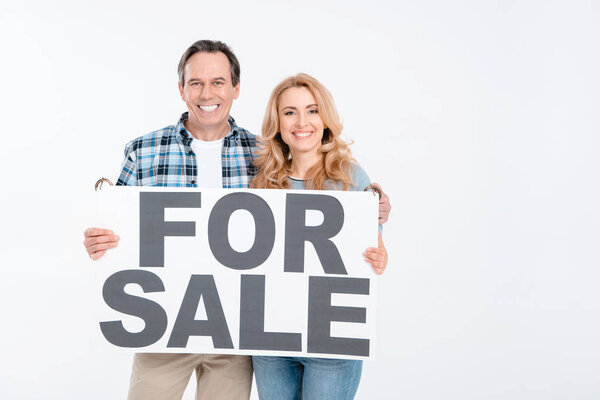 Couple with card "for sale"