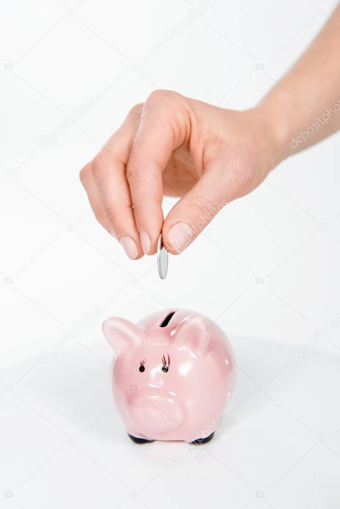 Putting coin in piggy bank