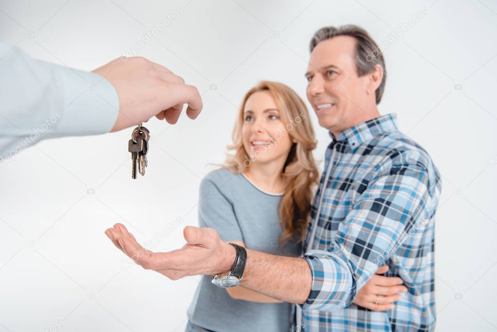 couple receiving keys from house 