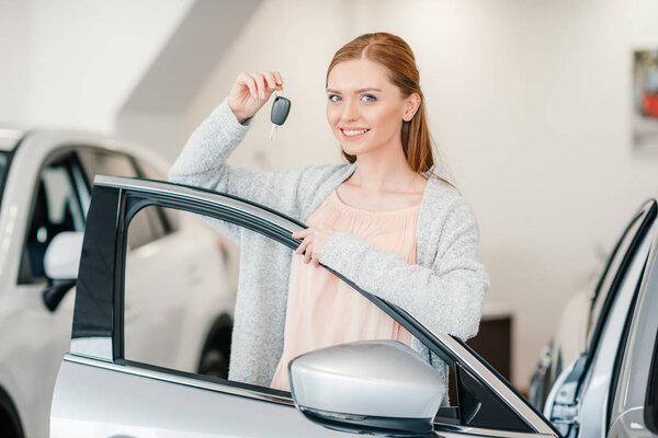 Женщина держит ключ от машины
