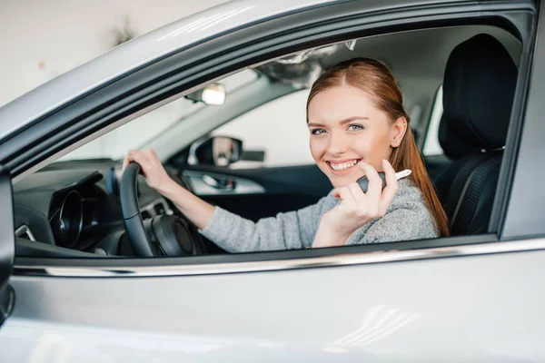 Frau sitzt in neuem Auto — Stockfoto