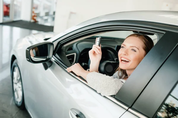 Frau sitzt in neuem Auto — Stockfoto