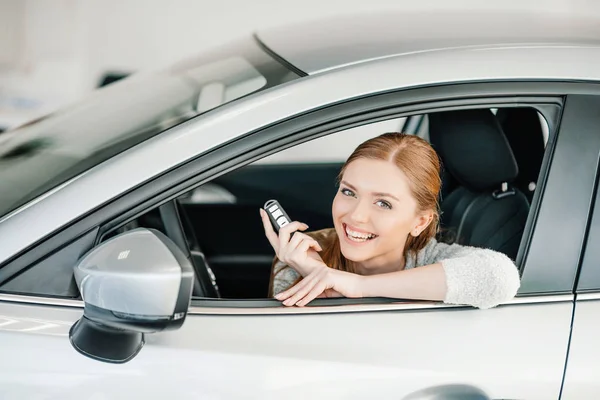 Frau sitzt in neuem Auto — Stockfoto