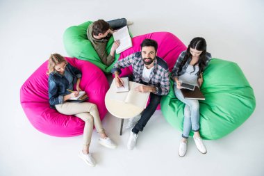 Beanbag sandalye üzerinde oturan öğrenciler