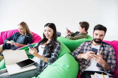 Beanbag sandalye üzerinde oturan öğrenciler