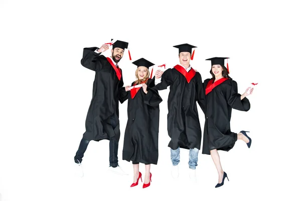 Students in graduation caps with diplomas — Stock Photo, Image