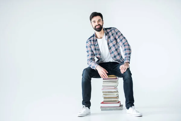 Kitap yığınının üzerinde oturan öğrenci — Stok fotoğraf