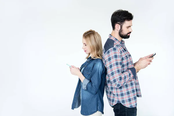 Мужчина и женщина с помощью смартфонов — стоковое фото