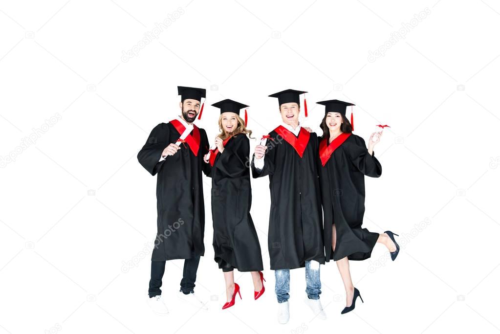 students in graduation caps with diplomas