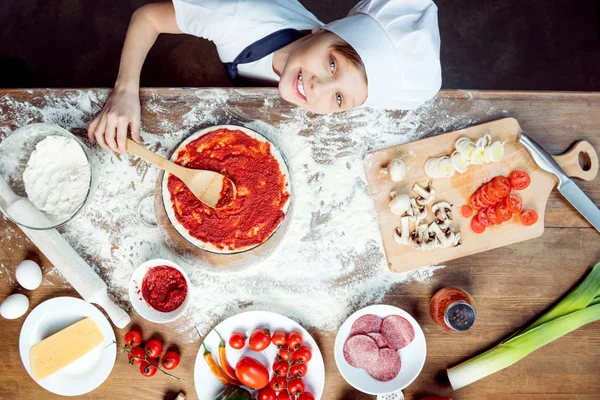 Jongen pizza maken — Stockfoto