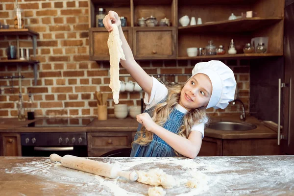 Girl playing with raw dough — Stock Photo, Image