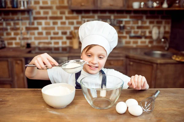 Мальчик наливает сахар в миску — стоковое фото