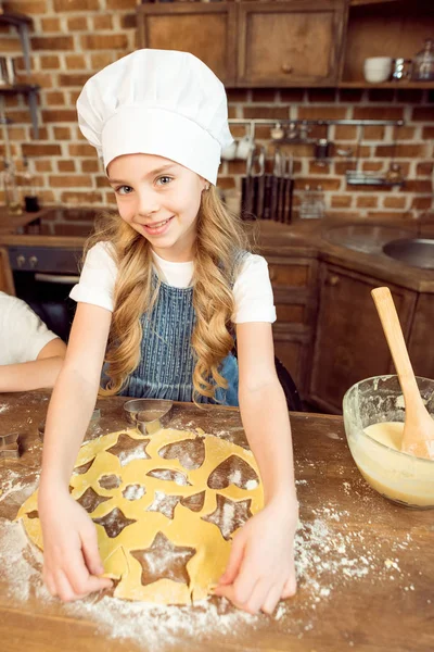 Flicka gör formade cookies — Stockfoto