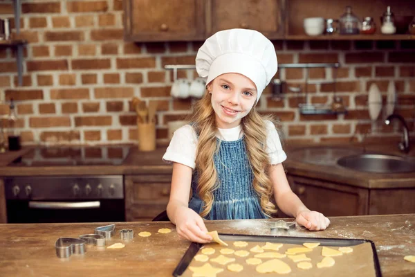 Flicka gör formade cookies — Stockfoto