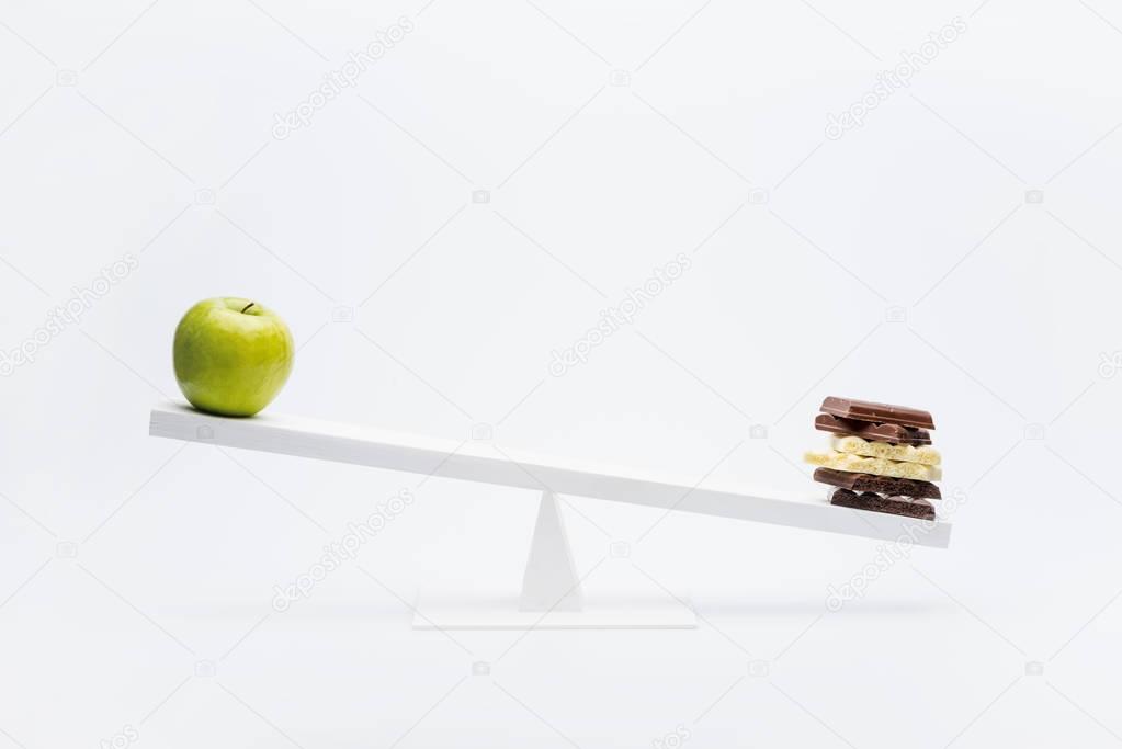 Apple and chocolate on seesaw 