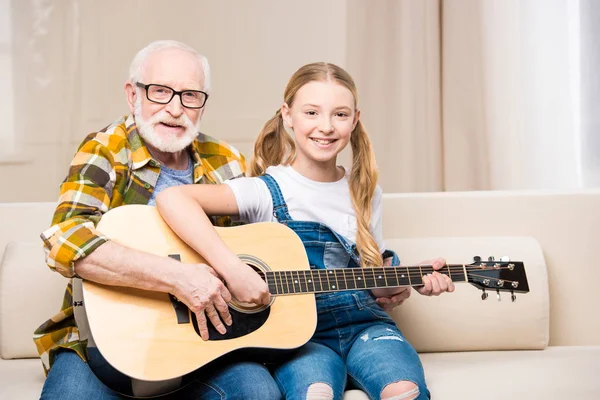 Grandfather and granddaughter with guitar — Free Stock Photo