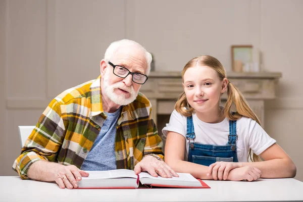 Grandfather with girl reading book — Stock Photo, Image