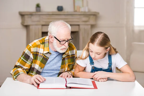 Grandfather with girl reading book — Stock Photo, Image