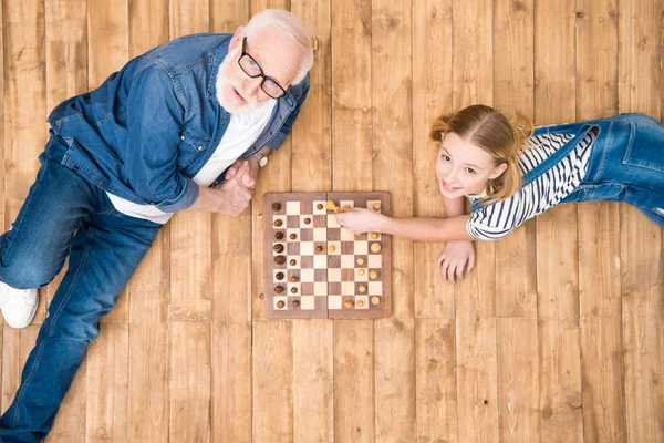 Abuelo y nieta jugando ajedrez — Foto de Stock