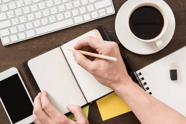 человек пишет в тетрадке