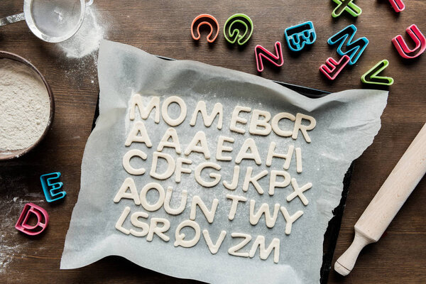 cookies in forms of letters with rolling pin