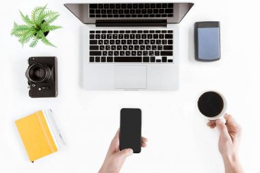 Smartphone ve kahve fincanı holding eller