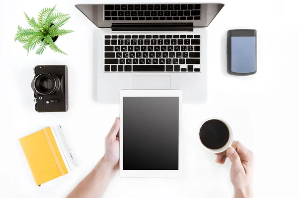 Hands holding tablet and coffee cup — Stock Photo, Image