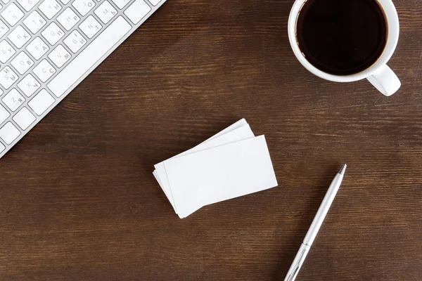 Coffee cup and cards on workplace — Stock Photo, Image