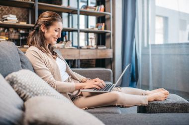 Woman typing on laptop clipart