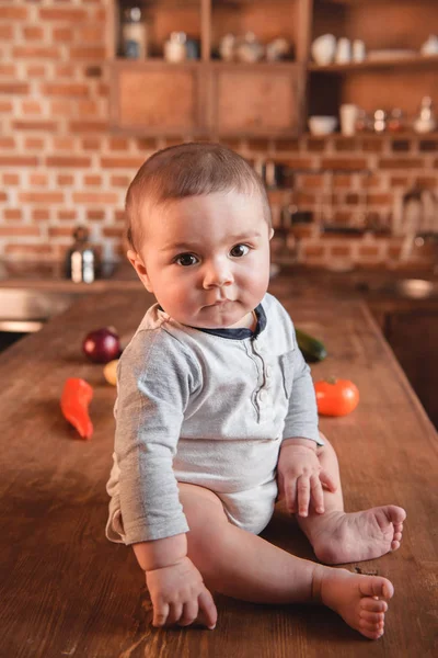 Маленький хлопчик на кухонному столі — стокове фото